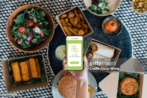 ordering takeaway meal online with smartphone - ordering food stock pictures, royalty-free photos & images