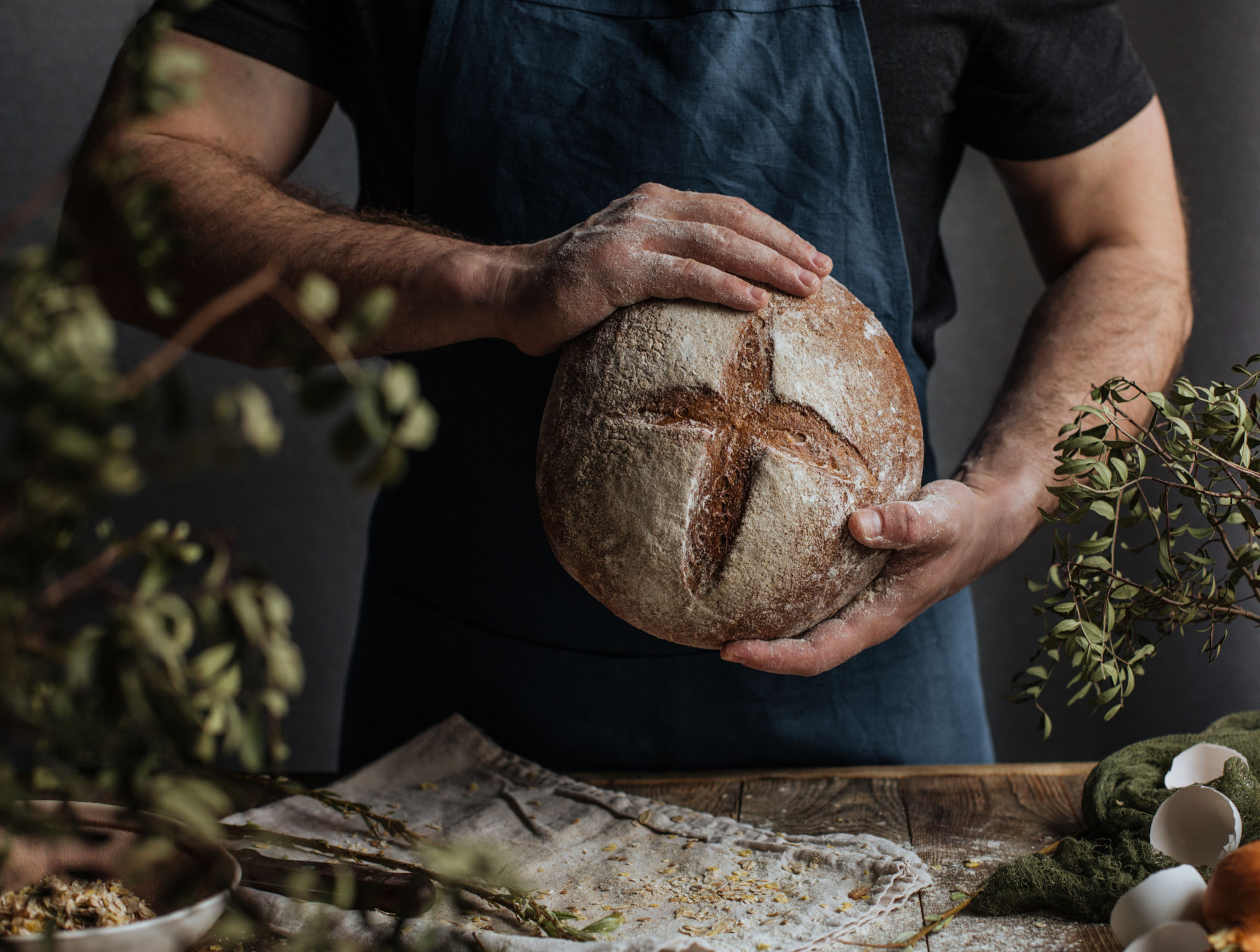 The Baker's hands hold a loaf of rye bread The Baker's hands hold a loaf of rye bread