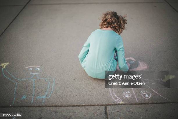 girl draws chalk child on sidewalk - sidewalk chalk drawing stock pictures, royalty-free photos & images