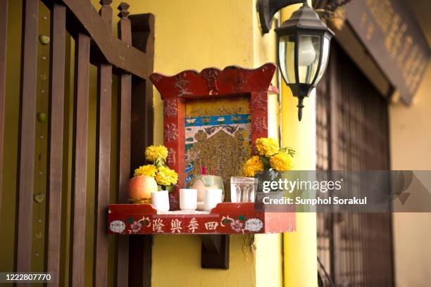 a small chinese shrine at the front of the terrace house in phuket old town - phuket old town stock-fotos und bilder