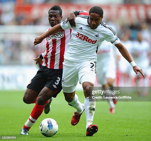 Asamoah Gyan of Sunderland battles for the ball with Ashley Williams of Swansea City during the Barclays Premier League match between Swansea City...