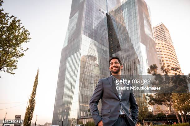 portrait of a handsome businessman - looking up at buildings stock pictures, royalty-free photos & images