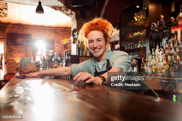 lächelnde weibliche bartender reinigungsbartheke - mop stock-fotos und bilder