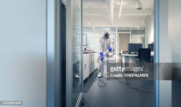professional spray and sanitation of a corporate office - disinfection stock pictures, royalty-free photos & images