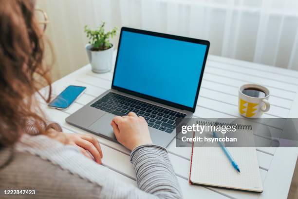 junge frau mit laptop mit leerer bildschirm - blank laptop screen stock-fotos und bilder