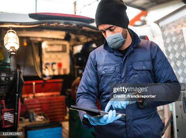 mechanic in front of the van with face mask - plumber van stock pictures, royalty-free photos & images