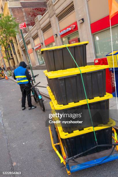 fiets bezorgservice op 6th avenue, new york city tijdens de covid-19 pandemie - industrial storage bins stockfoto's en -beelden