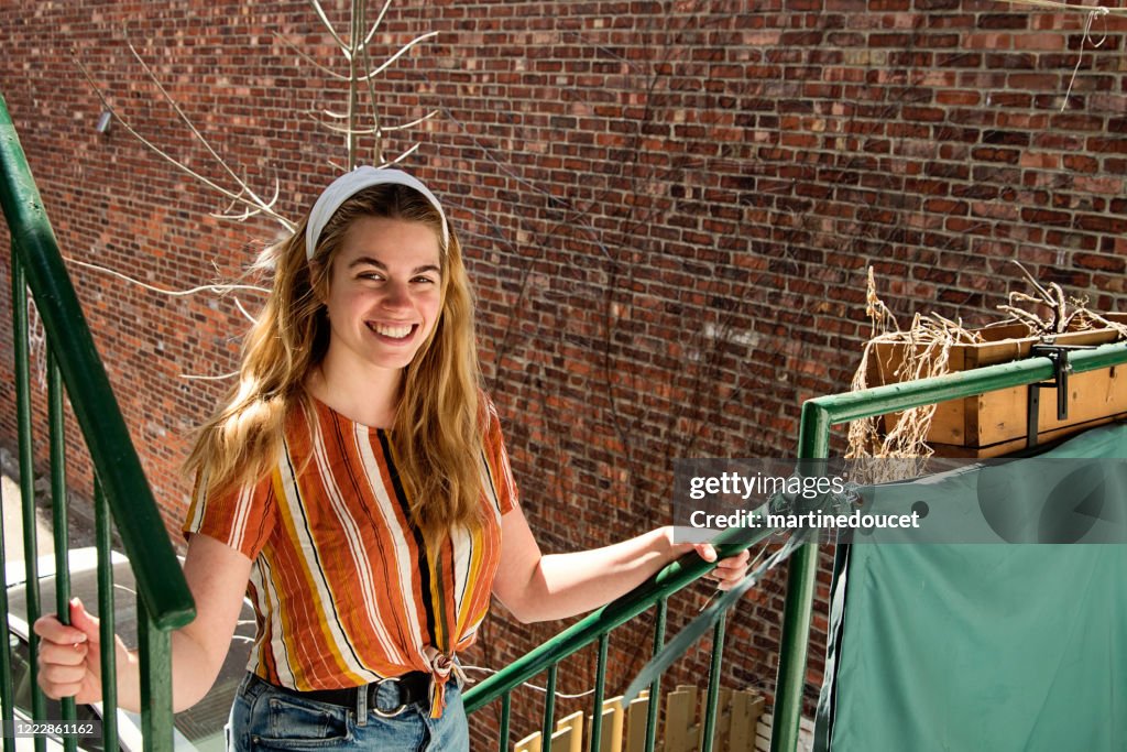 Millenial woman cleaning city balcony in spring.