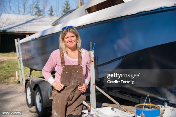 a mature woman restoring a boat - repairing boat stock pictures, royalty-free photos & images