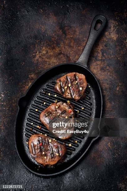 gegrilltes rindfleisch medaillons - gusseiserne pfanne stock-fotos und bilder