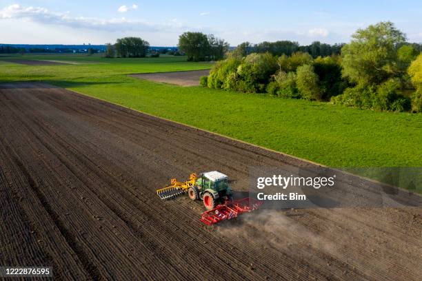 traktor pflügen feld im frühling, luftansicht - gepflügtes feld stock-fotos und bilder