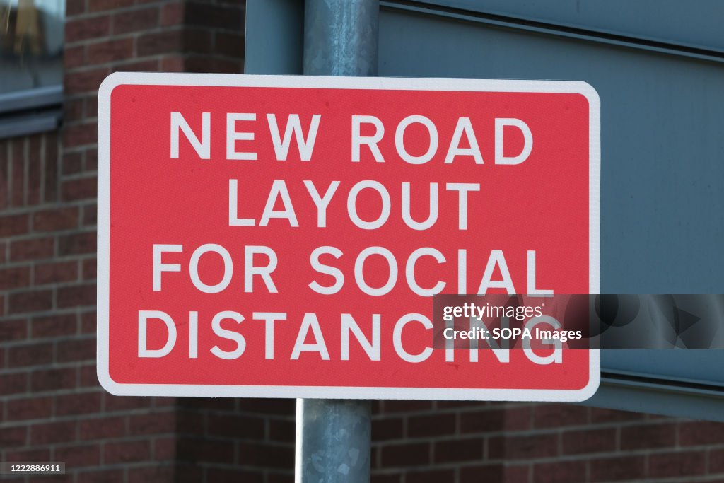 Temporary new road layout sign enforcing social distancing...