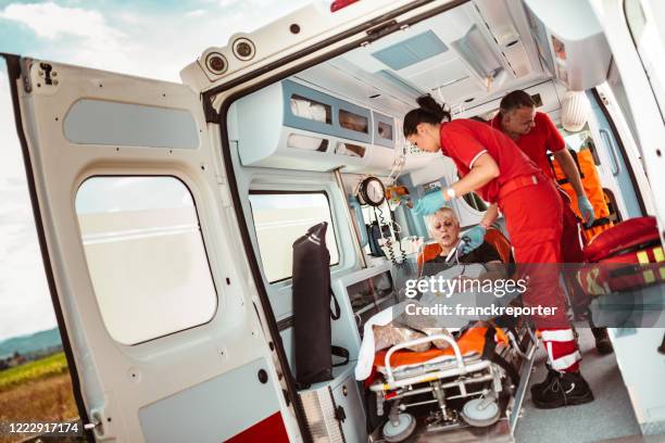 paramédico que cuida de una mujer en la ambulancia con el brazo roto - vehículo de emergencia fotografías e imágenes de stock