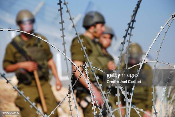 razor wire and soldiers - israel palestine conflict stockfoto's en -beelden