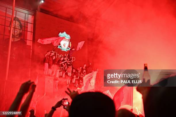Fans celebrate Liverpool winning the Premier League title outside Anfield stadium in Liverpool, north west England on June 25 following Chelsea's 2-1...