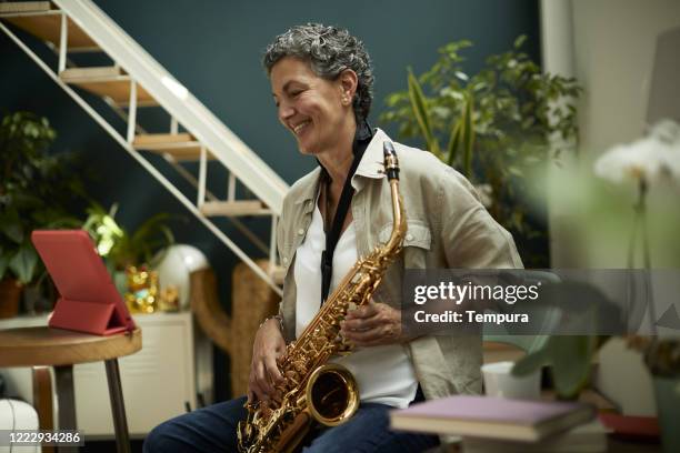 one woman learning music on line. - saxophon stock pictures, royalty-free photos & images