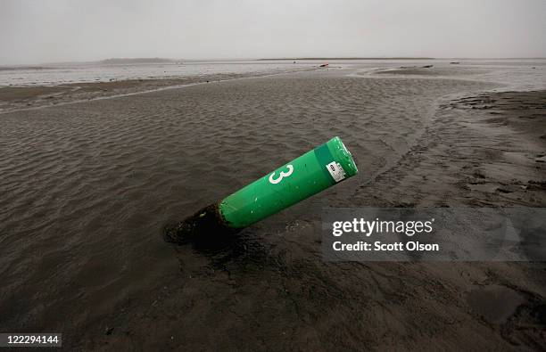 Buoy sits in mud in Kitty Hawk Bay in Albemarle Sound after the water was pushed out by Hurricane Irene August 27, 2011 in Kill Devil Hills, North...