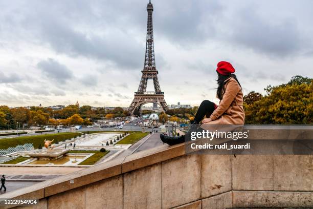 asian traveler sitting with eiffel tower view in paris - paris autumn stock pictures, royalty-free photos & images