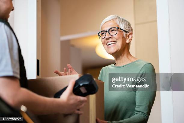 senior woman received package from courier - receiving box stock pictures, royalty-free photos & images