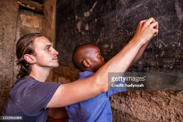 volunteer teaching in africa, orphanage in kenya - charity education stock pictures, royalty-free photos & images