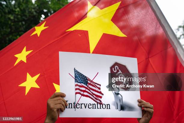 Pro-Beijing supporters hold China national flags and placards as they take part in a rally outside of Consulate General of the United States on June...