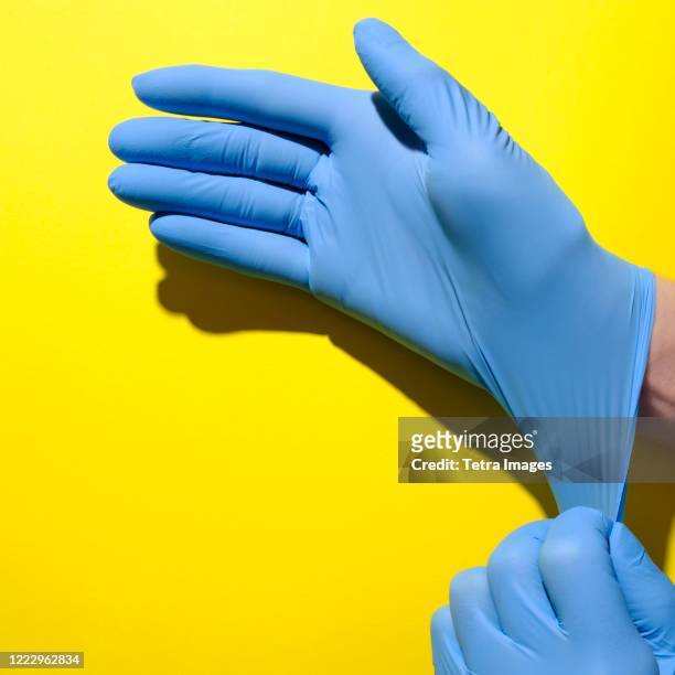 senior woman putting on surgical gloves - surgical glove stock pictures, royalty-free photos & images