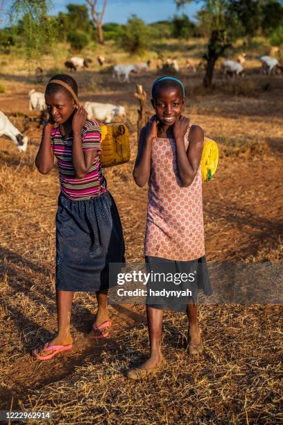 african children carrying water from the well, kenya, east africa - native african girls stock pictures, royalty-free photos & images