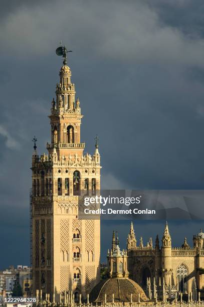 spain, seville, giralda and catherdral of seville, giralda tower with clouds - seville cathedral stock pictures, royalty-free photos & images
