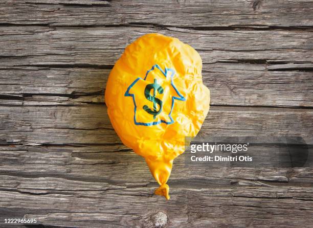delated ballon with dollar and house symbol - deflated stock-fotos und bilder