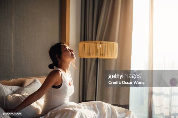 young woman waking up to a brand new day - waking up stock pictures, royalty-free photos & images