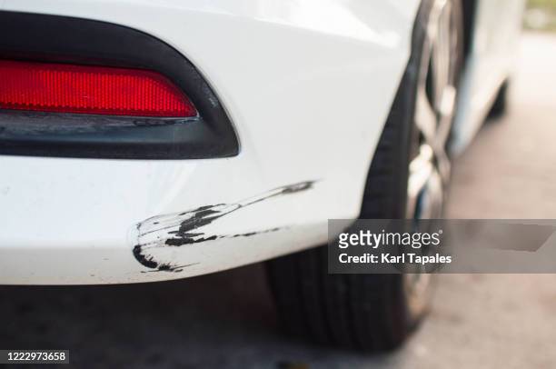 rear car bumper with damaged paint - abollado fotografías e imágenes de stock