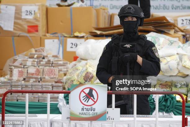 Thai police officer guards bags of confiscated narcotics drug during the 50th Destruction of Confiscated Narcotics ceremony to mark the International...