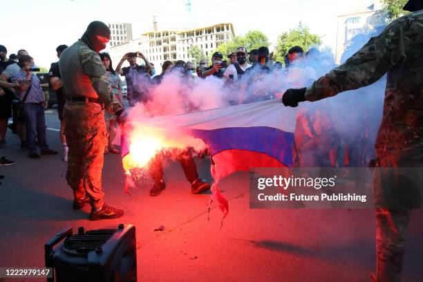 Men burn a Russian flag outside the office formerly occupied by the Opposition Platform - For Life Party during a flash-mob of right-wing activists,...