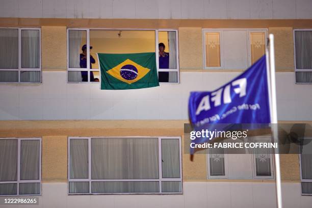 Staff member of the Brazil's team install a national flag in a window of the Protea Marine Hotel upon the arrival of the squad on late June 30, 2010...