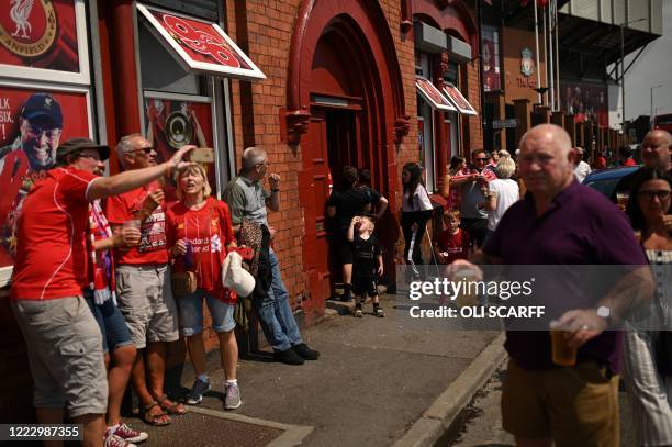 Liverpool fans drink takeaway draught beer in plastic cups outside The Albert pub, opposite Anfield stadium in Liverpool, north west England on June...