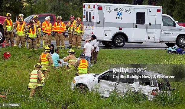 Goldsboro Police, Wayne County EMS, along with firefighters from Rosewood volunteer fire department gather around the victim of a fatal automobile...