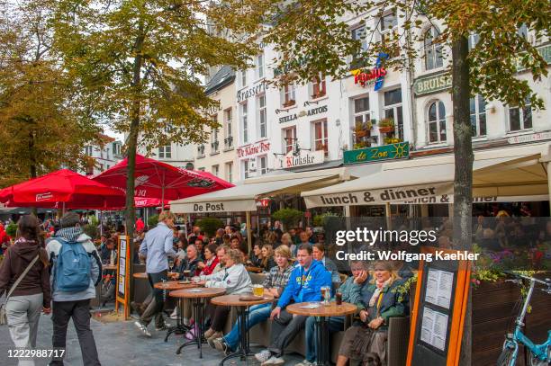 The market square with people enjoying the sidewalk cafes and restaurants in Antwerp, Belgium.