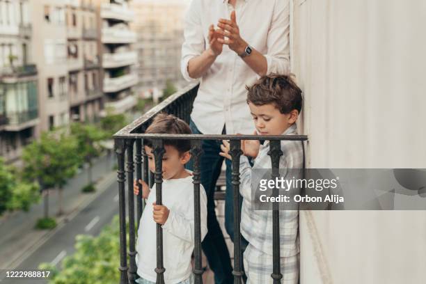 family applauding to the medical staff from the balcony for covid-19 - applauding balcony stock pictures, royalty-free photos & images