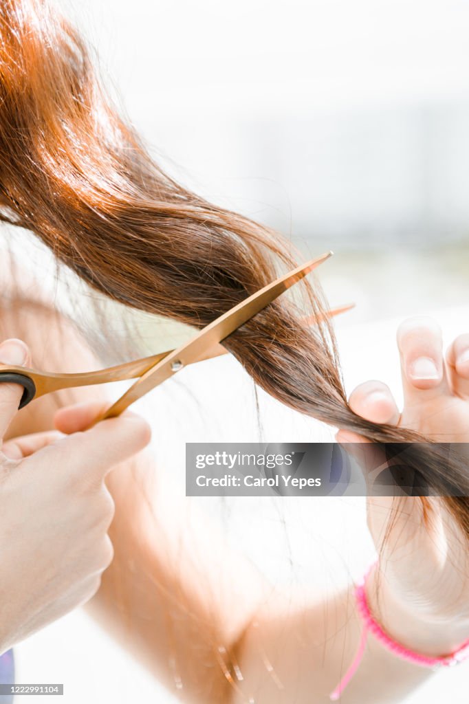 Woman trying to cut her own hair at home