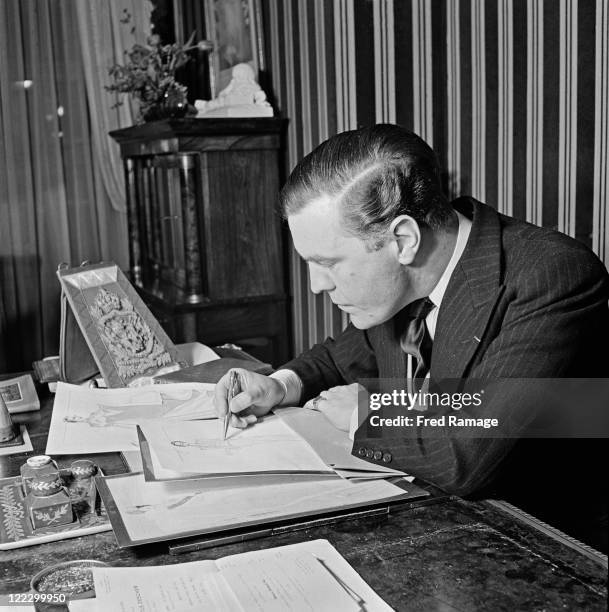 British fashion designer Norman Hartnell working at his Bruton Street salon in Mayfair, London, 31st January 1947.