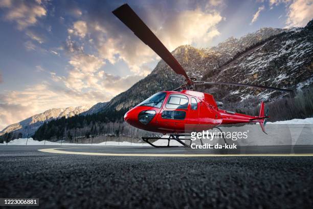 helikopter in de bergen bij zonsondergang - helikopterplatform stockfoto's en -beelden