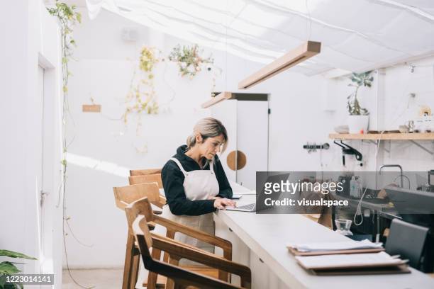 cafe manager working behind the counter - small business stock pictures, royalty-free photos & images