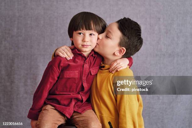 4-5 years old confident cute child and his brother portrait on gray background. - somente crianças imagens e fotografias de stock