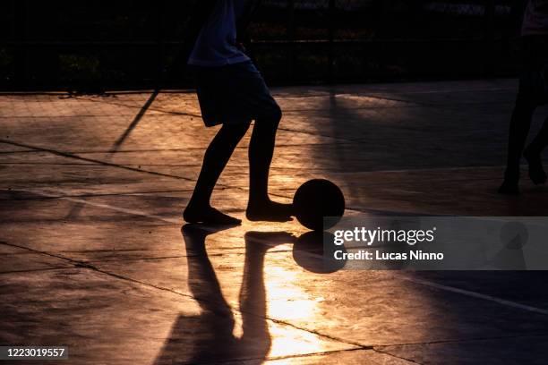 street soccer - silhouette - kids playing soccer street stock pictures, royalty-free photos & images