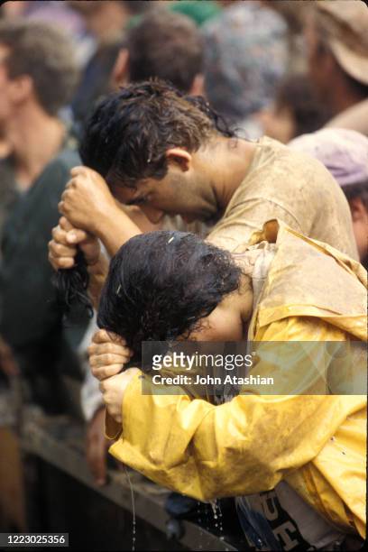 Concert fans are shown washing their hair at one of the few locations with running water at Woodstock 99 in Rome, New York on July 25, 1999.