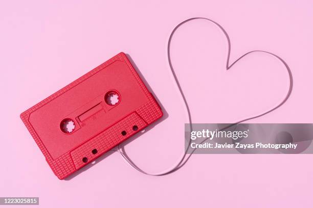 red cassette tape on pink background - tape recorder stock pictures, royalty-free photos & images