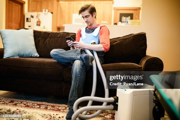 man using inhaler indoors - fibrosis stock pictures, royalty-free photos & images