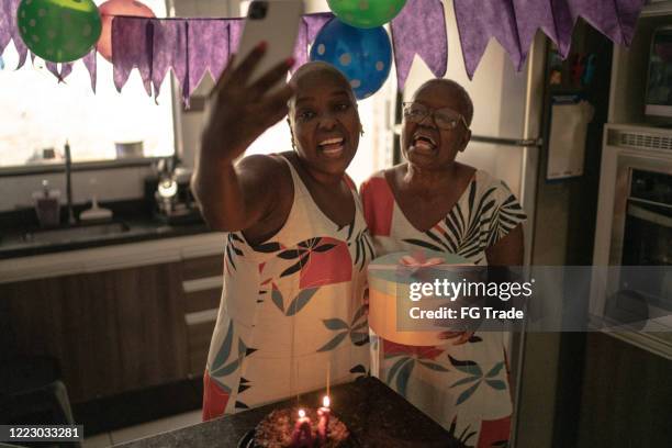 mãe e filha fazendo uma chamada de vídeo no celular celebrando festa de aniversário - mother daughter webcam - fotografias e filmes do acervo