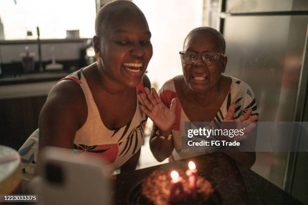 moeder en dochter die een videovraag op mobiele telefoon doen die de partij van de verjaardagsafstand viert - modern family media call stockfoto's en -beelden