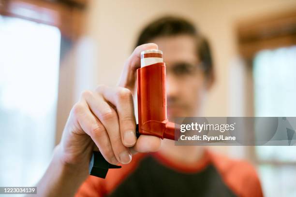 mann mit inhalator in innenräumen - asthmainhalator stock-fotos und bilder